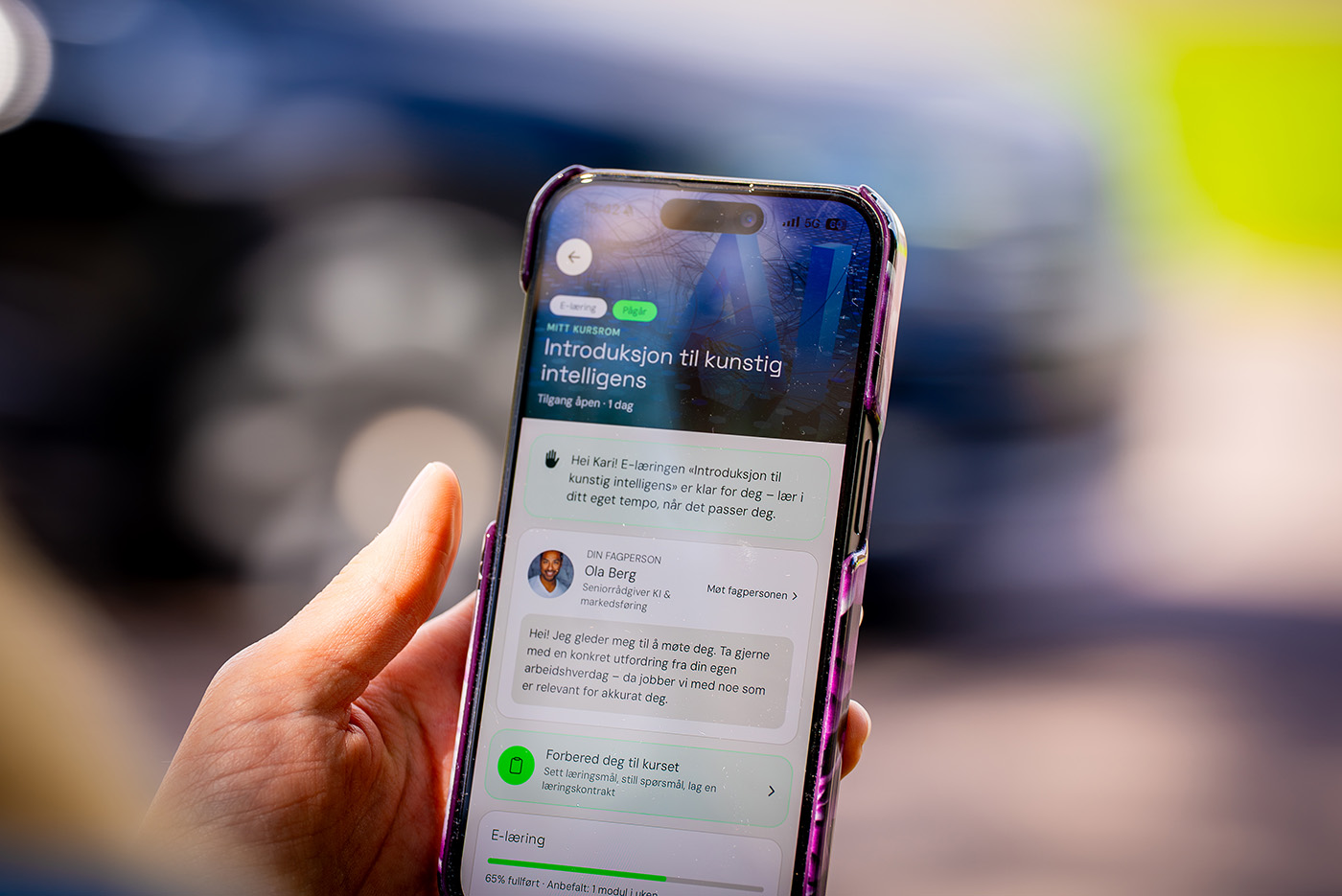 Person bruker mobiltelefon med et digitalt kurs i kunstig intelligens fra IGM.