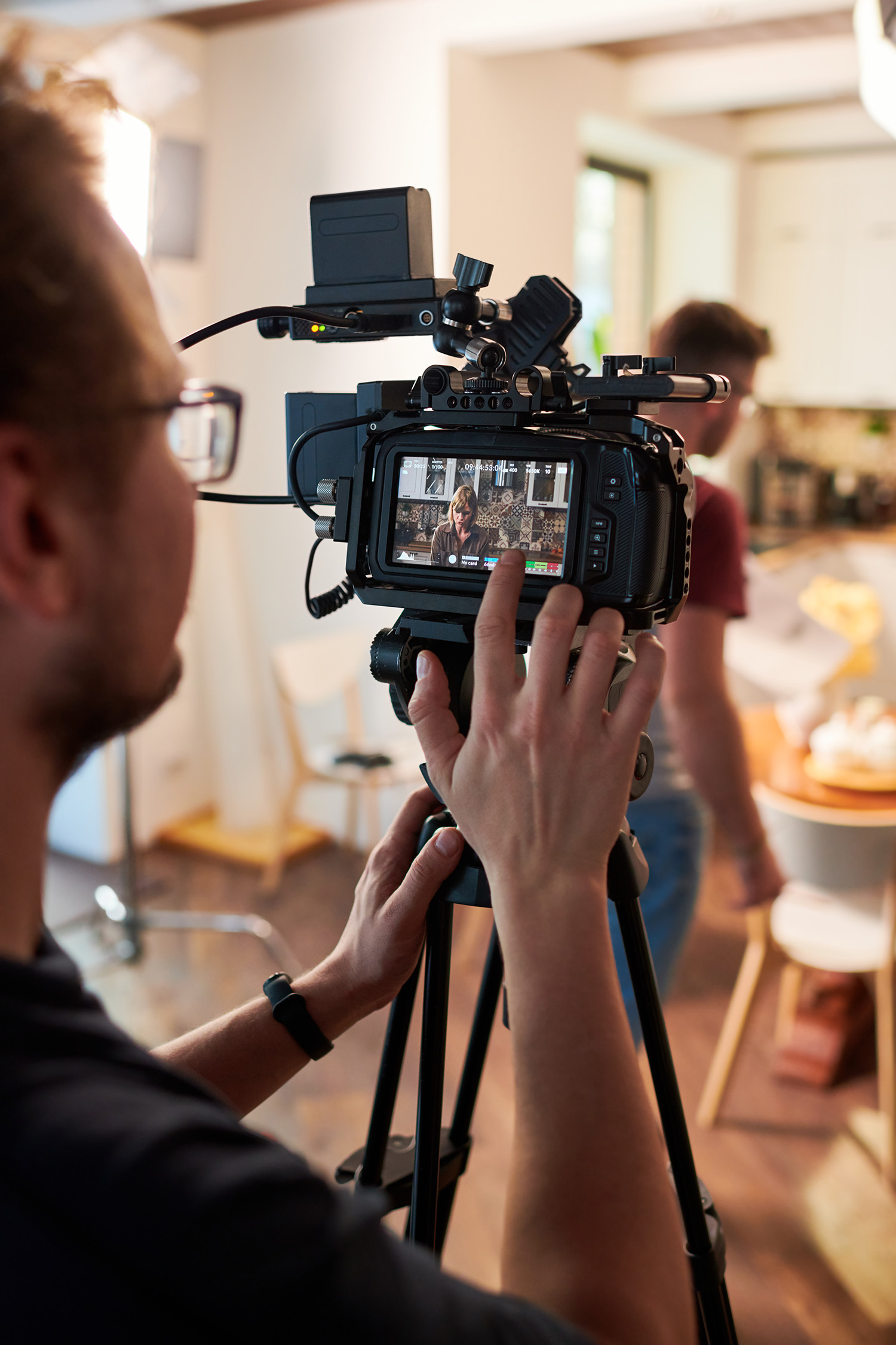 Fotograf filmer en person og kontrollerer bildet på kameraets monitor.