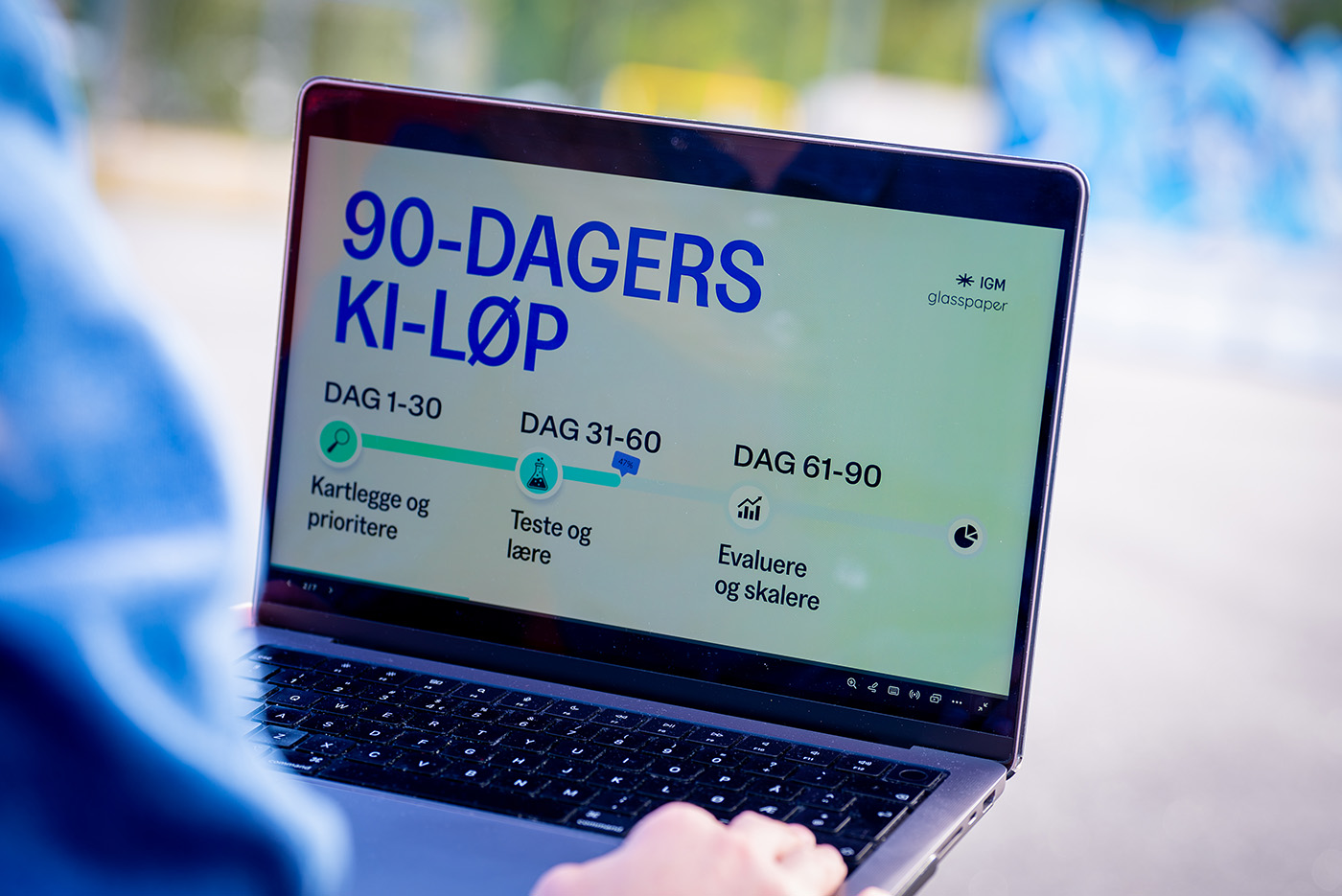 Person arbeider på laptop med en 90-dagers KI-plan delt i fasene kartlegge og prioritere, teste og lære, evaluere og skalere.